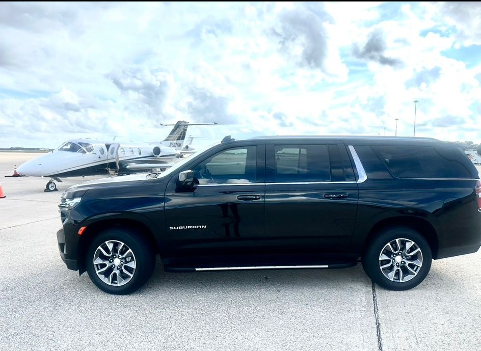 Executive SUV parked beside a private jet